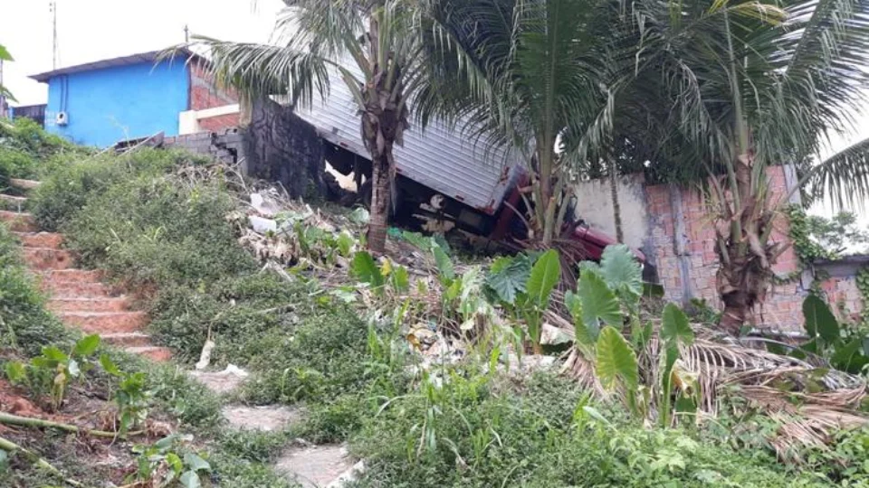 Motorista perde o controle de caminhão e veículo fica preso em estrutura de área residencial