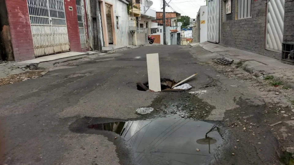 Buracos no asfalto são sinalizados por moradores após causar acidentes, no bairro Petrópolis
