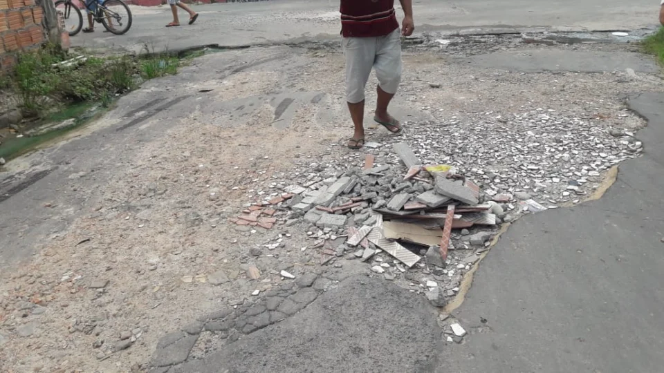 Moradores precisam tapar buracos com cascalhos para amenizar a situação da rua Edson, no bairro Novo Aleixo