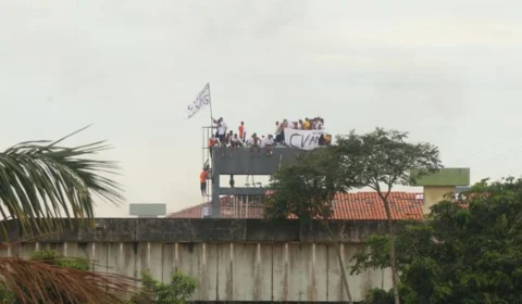 No telhado, detentos estedem bandeira de facção criminosa na UPP