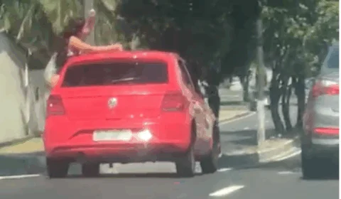 Mulher se arrisca na janela de carro e dança no meio do trânsito em Manaus