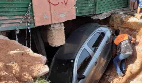 Motorista dorme ao volante e colide com carro estacionado na via e este cai em cratera gigantesca