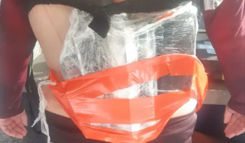 Mulher é presa com fuzil escondido debaixo da roupa