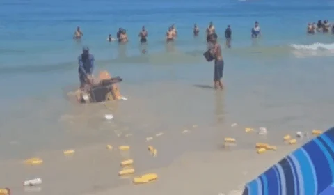 VEJA VÍDEO: carrinho de milho explode em praia e banhistas ajudam vendedor