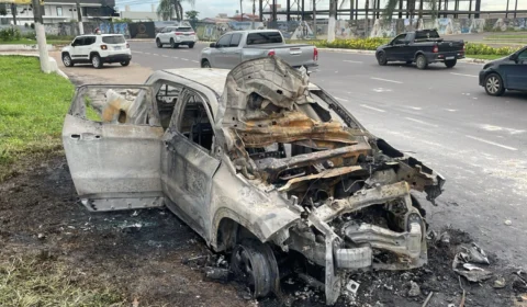 Carro colide contra poste, pega fogo e fica destruído