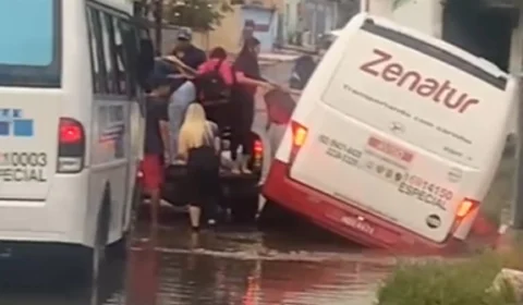 Micro-ônibus afunda em buraco coberto por alagamento no Armando Mendes