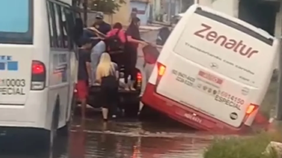 Micro-ônibus afunda em buraco coberto por alagamento no Armando Mendes