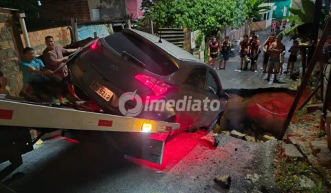 Carro cai em cratera e mobiliza moradores para resgate no bairro Tarumã, em Manaus