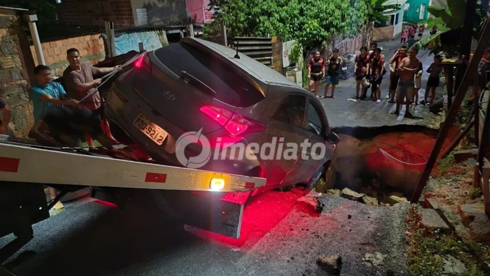 Carro cai em cratera e mobiliza moradores para resgate no bairro Tarumã, em Manaus