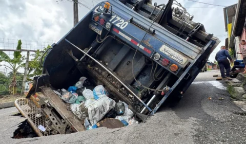 Caminhão de lixo cai em cratera e ameaça residências no bairro Tarumã