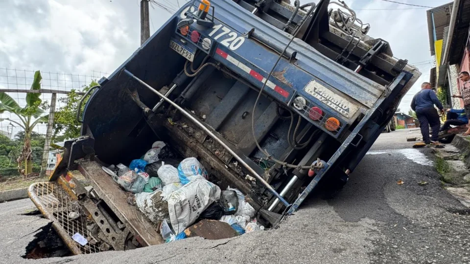 Caminhão de lixo cai em cratera e ameaça residências no bairro Tarumã