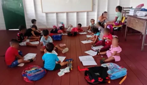 Crianças estudando sentadas no chão por falta de cadeiras em escola da zona rural de Breves, no Pará.