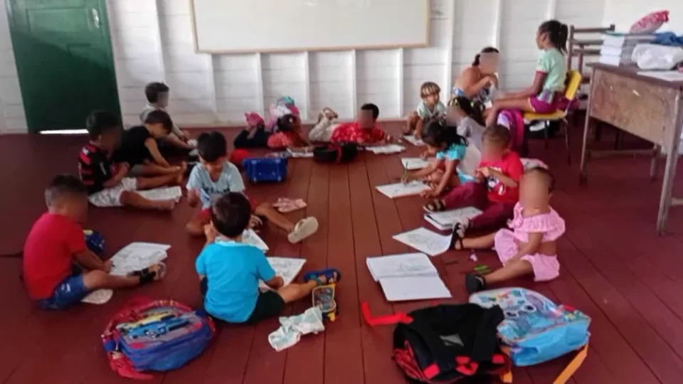 Crianças estudando sentadas no chão por falta de cadeiras em escola da zona rural de Breves, no Pará.