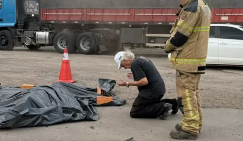Caminhoneiro se ajoelha e ora ao lado de corpo de motociclista após acidente fatal na BR-158