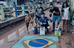 Jovens pintam bandeira do Brasil em rua de lama e momento repercute em Belém.