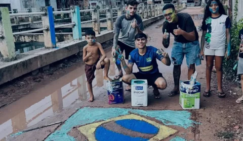 Jovens pintam bandeira do Brasil em rua de lama e momento repercute em Belém.