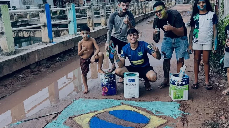 Jovens pintam bandeira do Brasil em rua de lama e momento repercute em Belém.